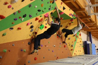 Grimpeurs sur le bloc de la salle d'escalade de Pollionay